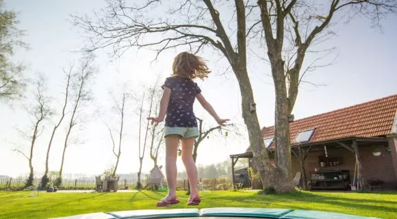 The little girl jumps on a trampoline in safety